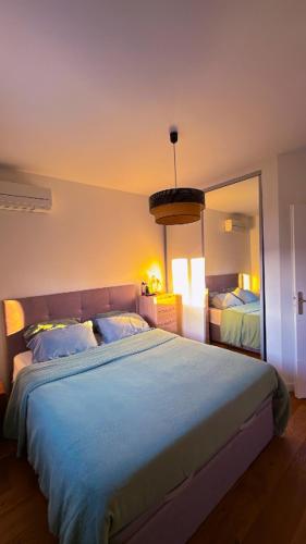 une chambre avec un grand lit et un grand miroir dans l'établissement Le soleil de pessac, à Pessac