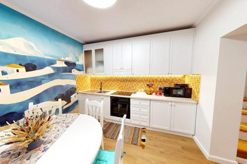 a kitchen with white cabinets and a painting on the wall at Villa Zen Oasis in Golem