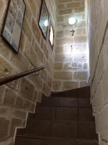 a staircase in a building with a stone wall at Favignana Vacanze in Favignana