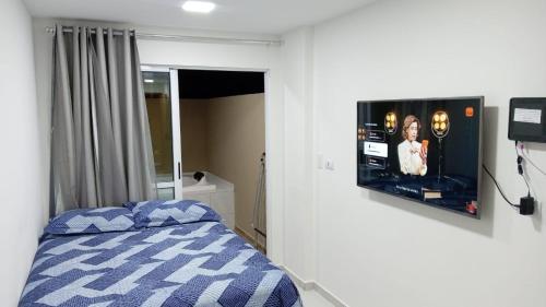 una camera da letto con un letto e una TV a parete di Flat Sol e Mar Residence Porto de Galinhas PE a Porto De Galinhas