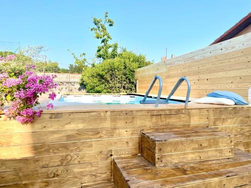a swimming pool with a wooden fence and flowers at Casetta sull’Etna in Nicolosi