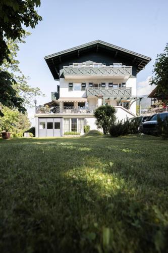 a large white building with a black roof at Alpstay - Chalet Hotel Hartmann - Adults Only in Ortisei