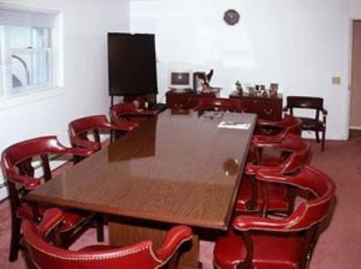 a conference room with a wooden table and red chairs at Margaretville Motel in Margaretville