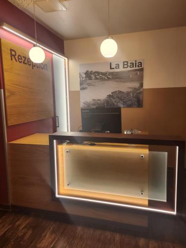 a reception desk in a room with a sign at Hotel La Baia in Cochem