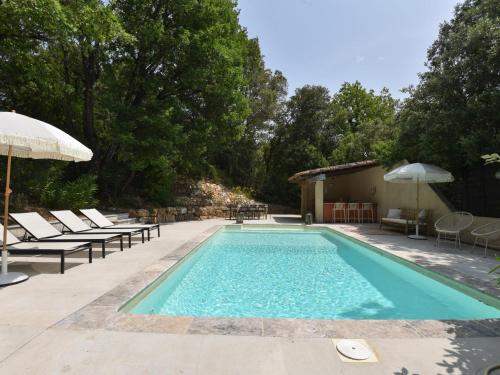 une piscine avec des chaises et un parasol dans l'établissement Rosamania, au Thoronet