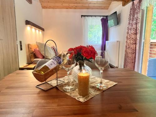 a table with two wine glasses and a candle at Chata POD HOUBOVÝM VRCHEM 2 in Horní Planá