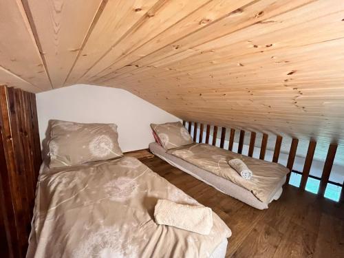 a room with two beds in a room with wooden ceilings at Chata POD HOUBOVÝM VRCHEM 2 in Horní Planá