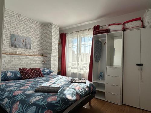 une chambre avec un lit et un mur de briques dans l'établissement Chaleureuse Maison Familiale Etretat Plage, à Étretat