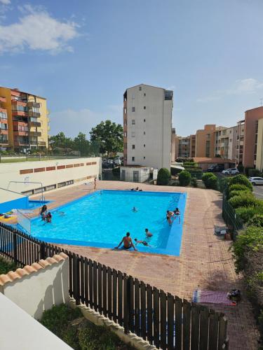 un groupe de personnes nageant dans une piscine dans l'établissement La Cabane vue mer et port, au Cap d'Agde
