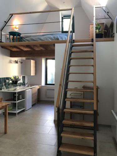 a staircase leading up to a loft bed in a kitchen at Gîte dans un petit village pyrénéen in Lézignan