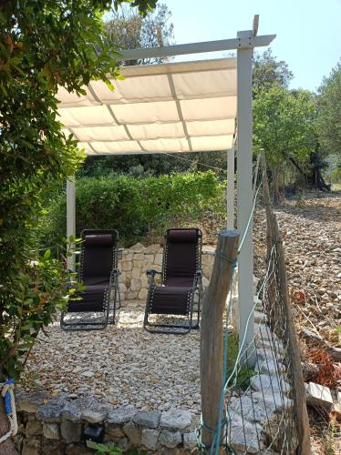 two chairs sitting under a pergola at Holiday Home Ruby in Sveti Jakov