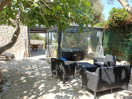 a patio with a grill and chairs under a tree at Holiday Home Ruby in Sveti Jakov