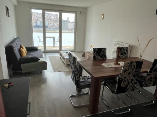 un salon avec une table et des chaises en bois dans l'établissement Charmant T3 avec balcon et parking, à Strasbourg