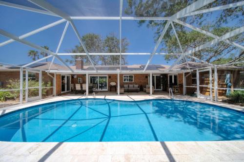 a large swimming pool with a large roof at Lighthouse Retreat With A Pool in Ponce Inlet