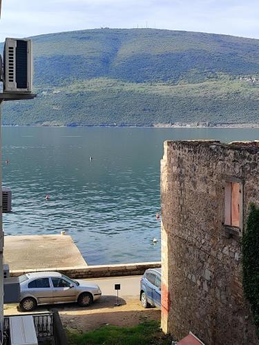 two cars parked next to a large body of water at Apartments Skipper bay Baosici in Baošići