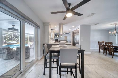 a dining room with a table and chairs and a ceiling fan at Lighthouse Retreat With A Pool in Ponce Inlet