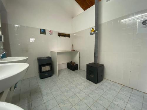a bathroom with two sinks and a heater in the floor at DOMOS GLAMPING Agreste Bahía Rosales in Parque Nacional Los Alerces