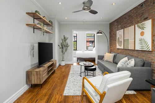 a living room with a couch and a tv at Chic NYC Escape in Vibrant Downtown in New York