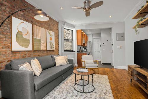 a living room with a couch and a brick wall at Chic NYC Escape in Vibrant Downtown in New York
