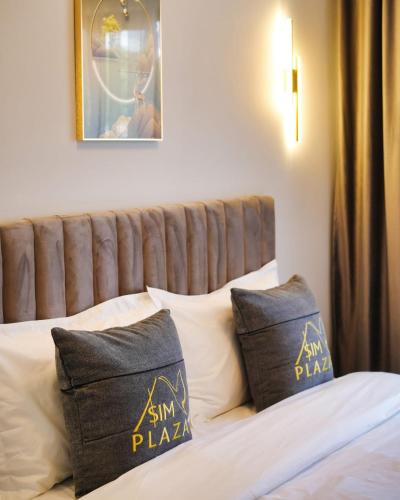 a bed with black and gold pillows on it at Sim Plaza Hotel in Ejmiatsin