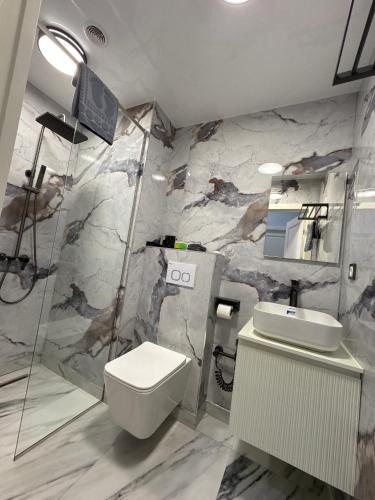 a bathroom with a shower and a toilet and a sink at Sim Plaza Hotel in Ejmiatsin