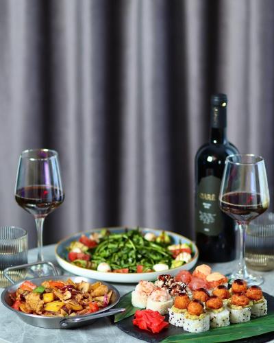 a table with two plates of food and a bottle of wine at Sim Plaza Hotel in Ejmiatsin
