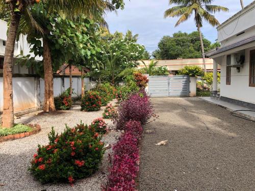 a driveway with flowers in front of a house at Belhaven Home Stay in Trivandrum