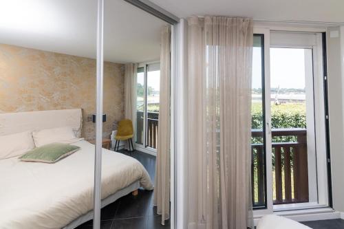a bedroom with a bed and a balcony at Appartement Lac marin in Vieux-Boucau-les-Bains
