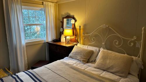 Un dormitorio con una cama y un espejo y una ventana. en Serenity Lake House, en Palms