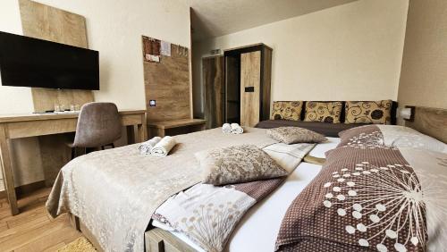 a bedroom with a bed and a desk with a television at SEDRA Holiday Resort-Adults Only-Bed & Breakfast in Grabovac