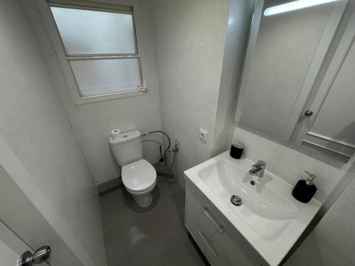 a bathroom with a toilet and a sink and a mirror at Apartamentos en la rambla in Sant Feliu de Guixols