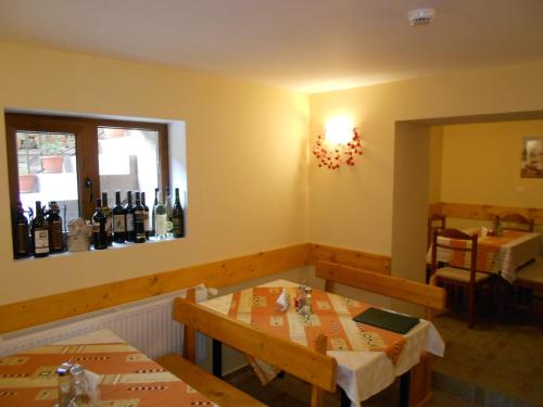 a restaurant with two tables and wine bottles on the wall at Guest House Tsenovi in Koprivshtitsa