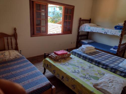 a room with three bunk beds and a window at Pousada da Prata in Águas da Prata