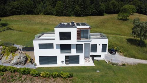 an aerial view of a white house on a hill at Anton's Apartment - Natur & See in Velden am Wörthersee