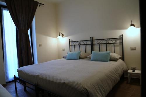 a bedroom with a large bed with blue pillows at Agriturismo Dai Marchesin in Nasino
