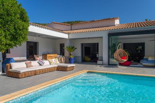 - une piscine avec un canapé et une maison dans l'établissement Beautiful Modern villa lei Suza with great pool exotic garden, à Solliès-Pont