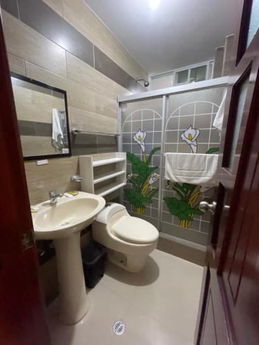 a bathroom with a toilet and a sink at Hostal Balcon del Cielo in Baños