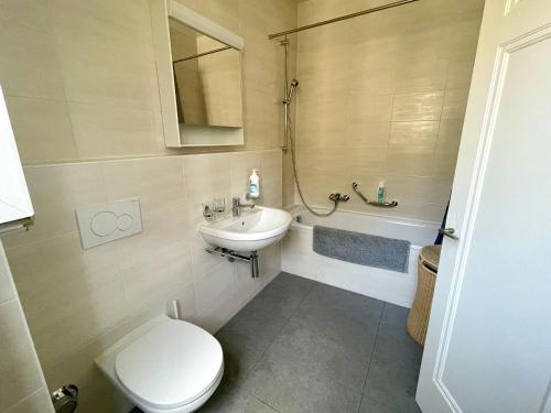 a bathroom with a toilet and a sink and a tub at 6 minutes walking from Lausanne railway station in Lausanne