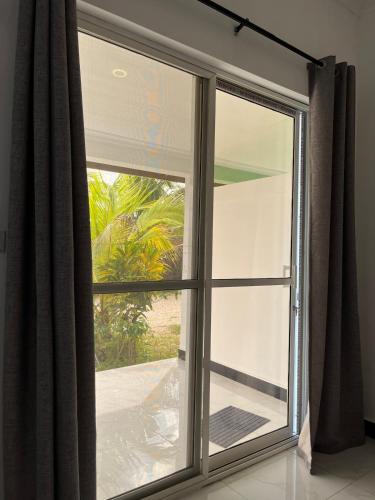 a window with a view of a palm tree at Spacious Room in Paje in Paje