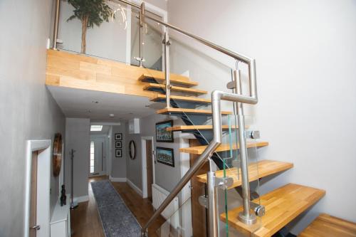 a staircase in a home with wooden treads at Penthouse at the White House near Edinburgh in Bathgate