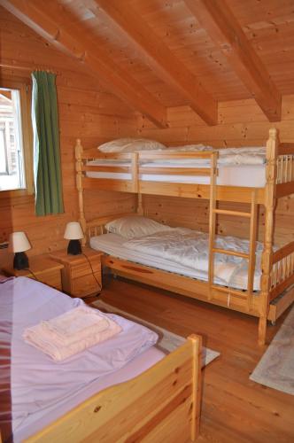 a bedroom with two bunk beds in a log cabin at Chalet Le Grand Darrey in La Fouly