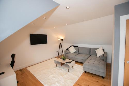 a living room with a couch and a table at Penthouse at the White House near Edinburgh in Bathgate