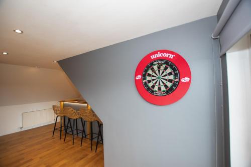 a dart board on the wall of a room with stools at Penthouse at the White House near Edinburgh in Bathgate