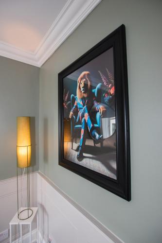 a picture of a dog sitting in a chair on a wall at Penthouse at the White House near Edinburgh in Bathgate