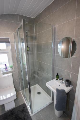 a bathroom with a shower and a sink and a toilet at Penthouse at the White House near Edinburgh in Bathgate