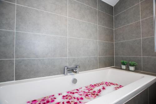 a bathroom with a bath tub with a towel on it at Penthouse at the White House near Edinburgh in Bathgate