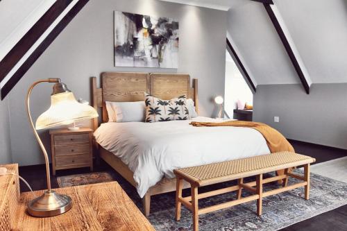 a bedroom with a bed and a lamp and a table at Palm Villa Beachfront Accomodation in Hentiesbaai