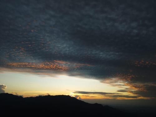 a cloudy sky with the sun setting behind a mountain at Ella Retreat Hotel Glamping Tent For Nature Lovers in Ella