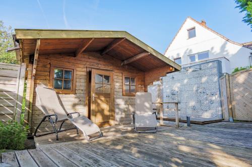 a house with two chairs and a table on a deck at Hotel Morgensonne garni in Büsum