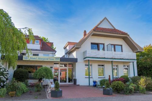 a white house with a sign in front of it at Hotel Morgensonne garni in Büsum